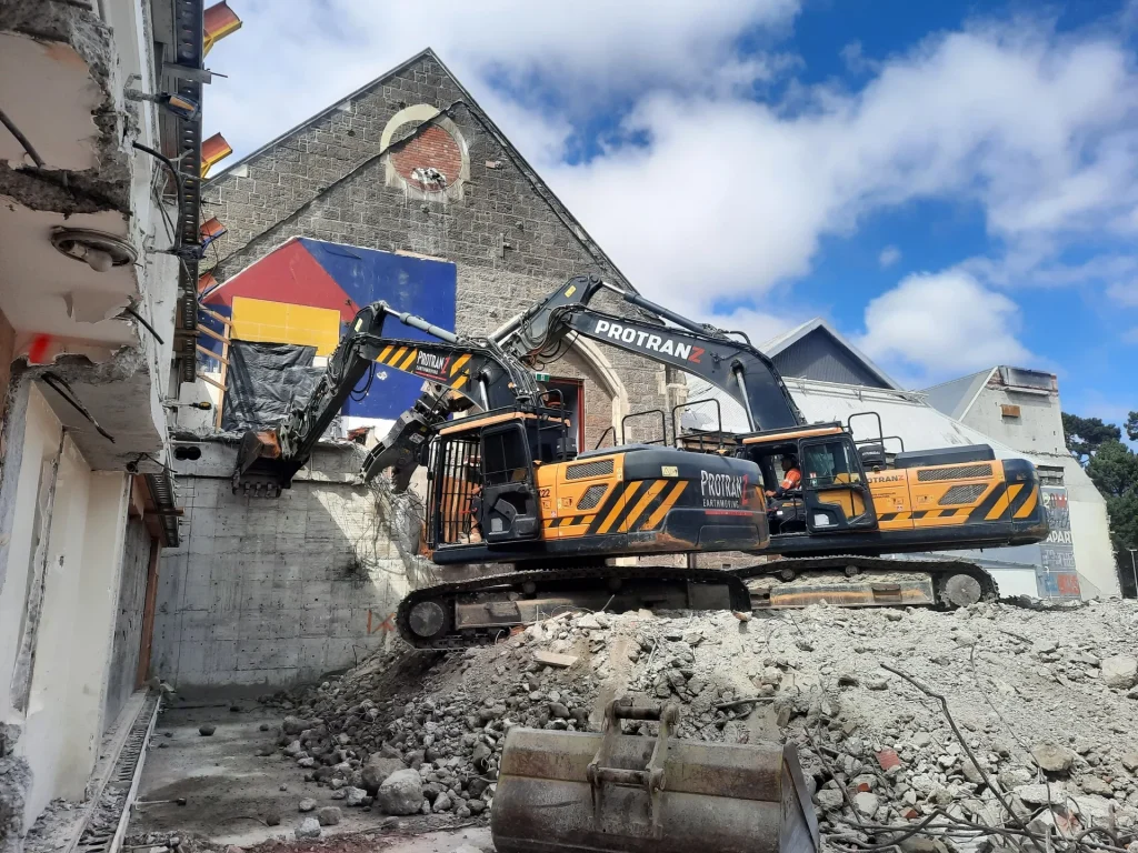 Two protranz differs working together to demolish a building